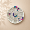 Petit panier artisanal en fibres de palmier motif 1, vue du dessus sur fond beige