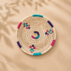 Petit panier artisanal en fibres de palmier motif 3, vue du dessus sur fond beige